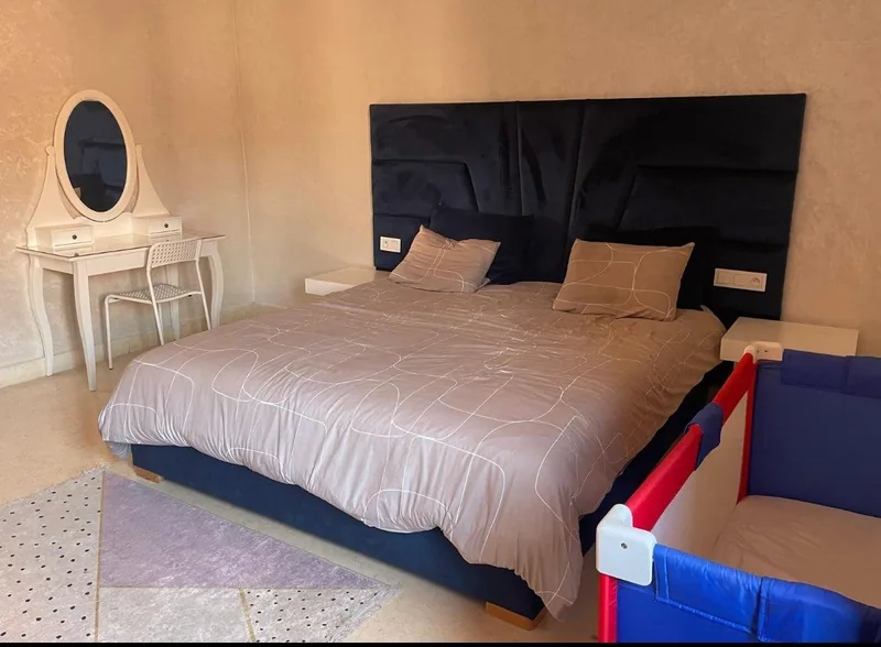 Chambre a coucher avec lit king size ainsi qu'un lit parapluie pour enfants en bas age